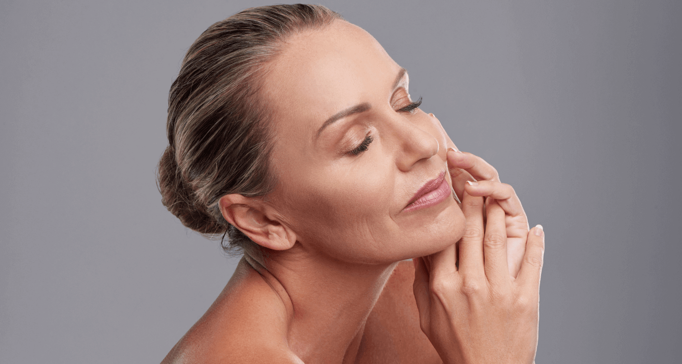 woman touching her face after receiving jawline fillers at Medisha Clinic