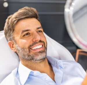 Man looking in the mirror after rhinoplasty at medisha clinic